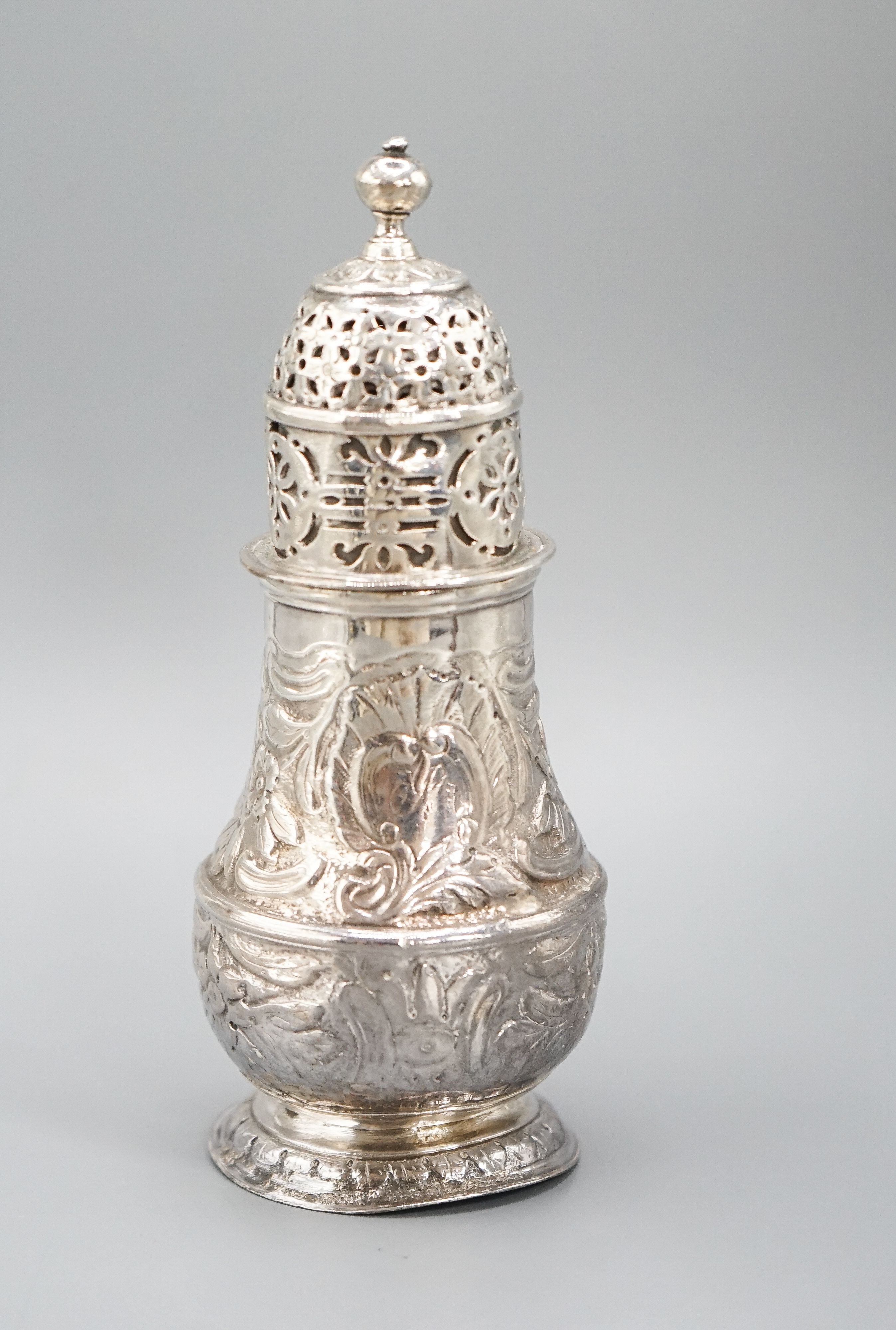 A George I silver sugar caster, with later? embossed decoration, Charles Adam, London, 1716, 13.5cm, 4.5oz.